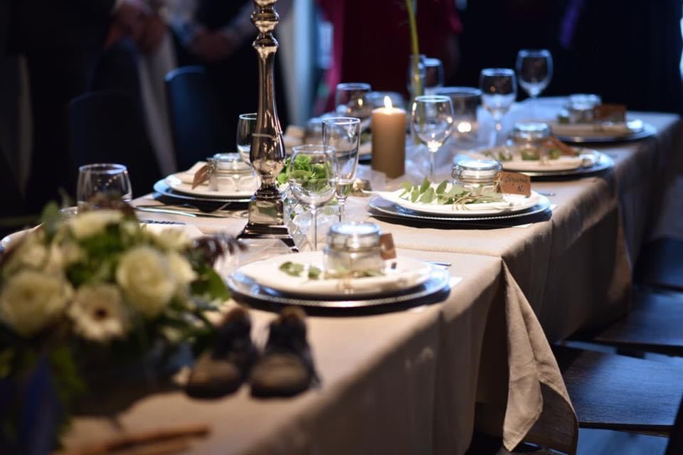 Langbord dekket til konfirmasjon med levende lys og grønne planter