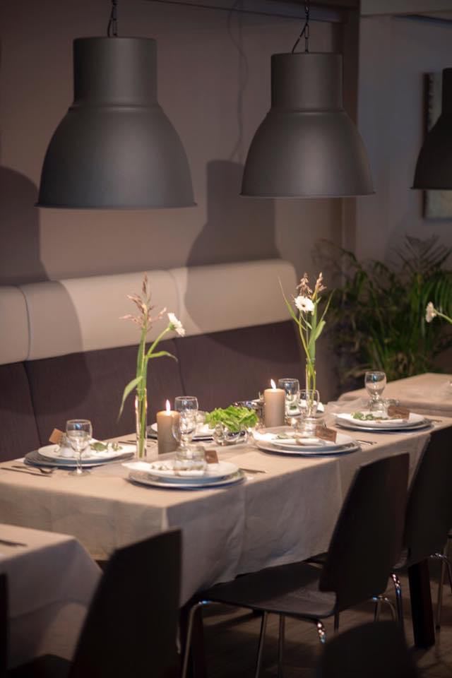 Borddekking med hvite servietter og blomsterdekorasjoner til konfirmasjon